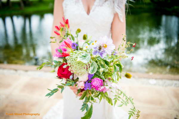 Colourful wildflower boho bride's bouquet for Jess at Wethele Manor, Warwickshire. Wedding flowers by Tuckshop Flowers, Birmingham, West Midlands.