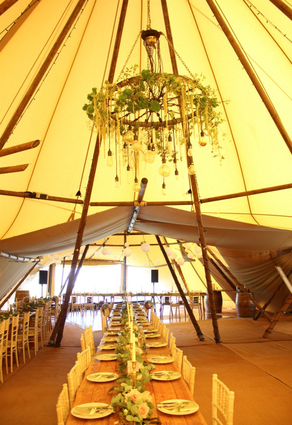 Cartwheel chandelier with hanging foliage for a tipi wedding at Alcott Weddings, Worcestershire.