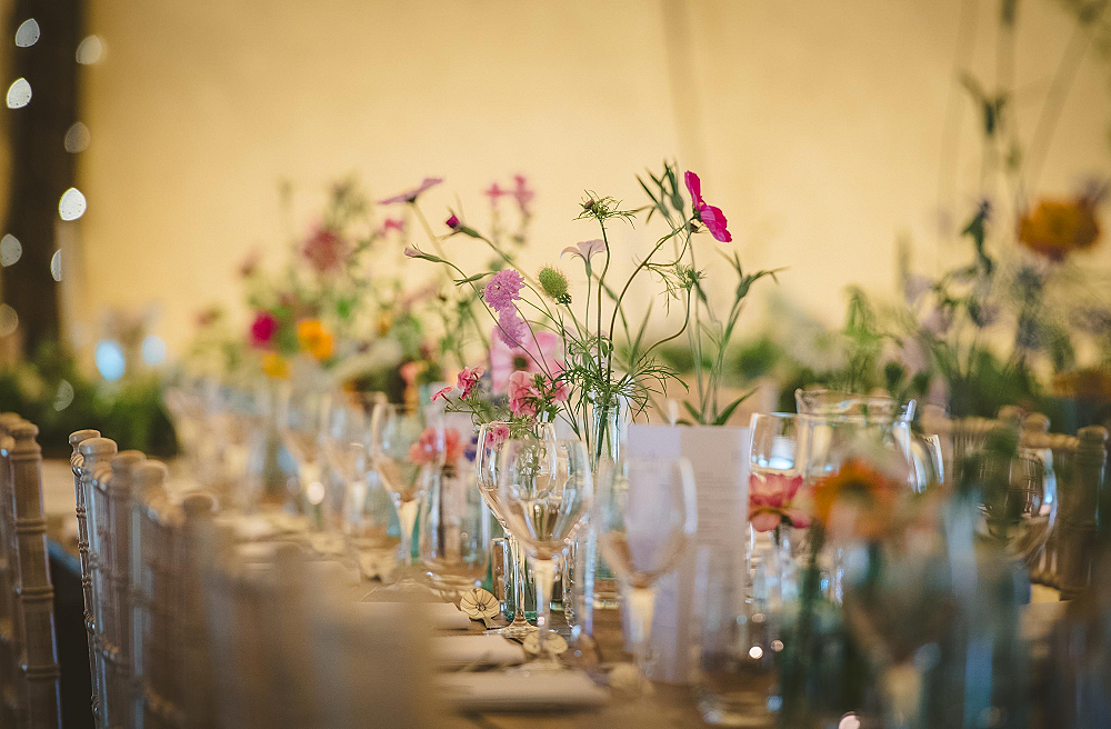Inspiration for wedding reception flowers - garden gathered flowers in  bottles form a central table runner for this wedding table at Alcott Weddings, Worcestershire. 